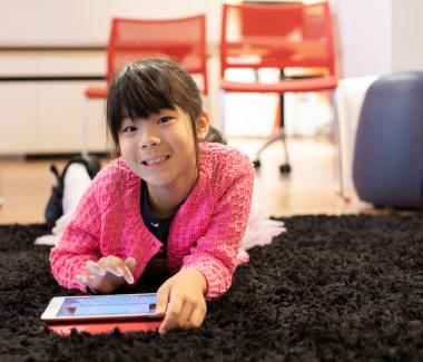 A girl lying down with an ipad